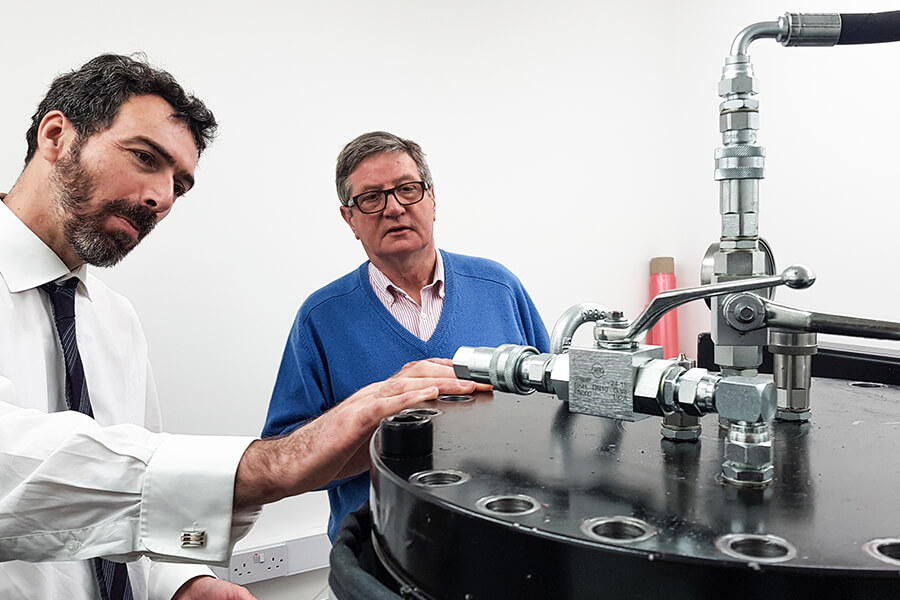 Two men examine a piece of equipment